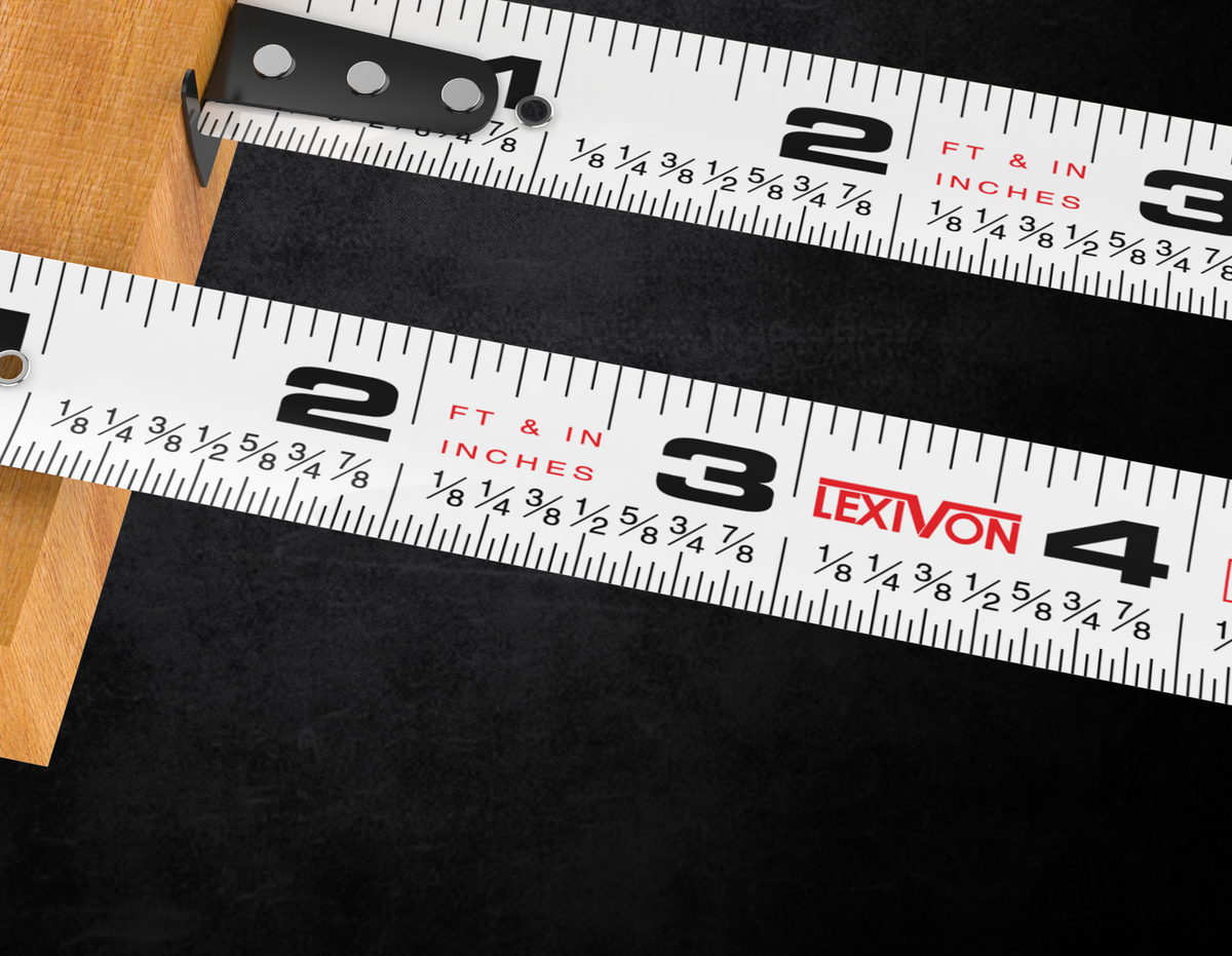 Tape blade detail showing inch graduations, printed fractions and the movable hook against wood